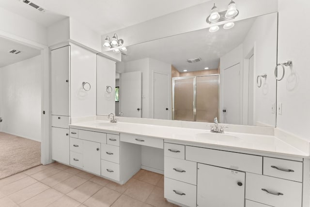 bathroom featuring a stall shower, tile patterned floors, and double vanity