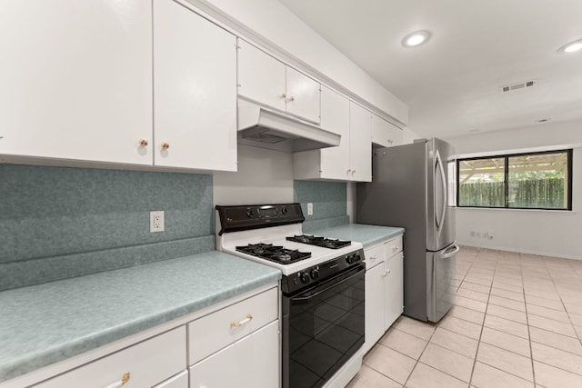kitchen featuring range with gas cooktop, under cabinet range hood, freestanding refrigerator, light countertops, and white cabinetry