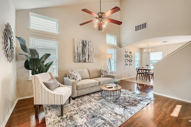 living area with high vaulted ceiling, a chandelier, dark wood-style floors, healthy amount of natural light, and a ceiling fan