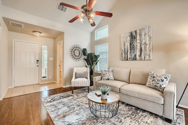 living room featuring wood finished floors, ceiling fan, baseboards, and high vaulted ceiling