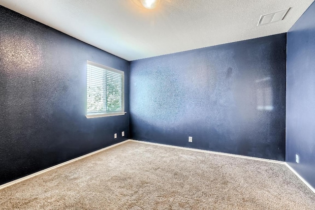 carpeted empty room featuring baseboards