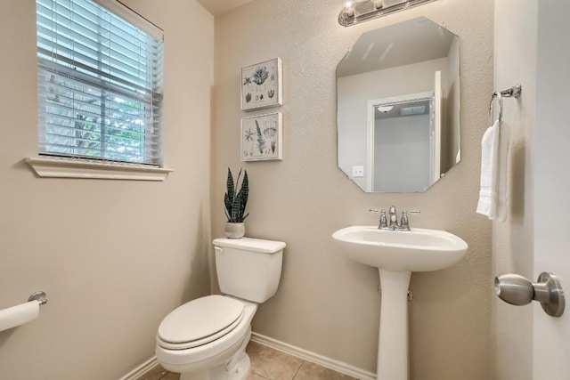 bathroom featuring toilet, tile patterned floors, and baseboards