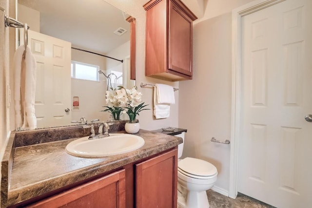 bathroom with toilet, vanity, and a shower