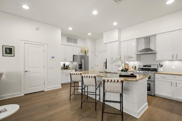 2520 Bluebonnet Ln Unit 32, Austin, TX 78704 - kitchen with stainless steel appliances, wall chimney exhaust hood, dark wood-style floors, a breakfast bar area, and a sink