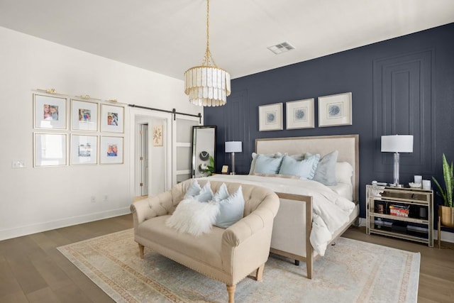 2520 Bluebonnet Ln Unit 32, Austin, TX 78704 - bedroom featuring a barn door, wood finished floors, a chandelier, and baseboards