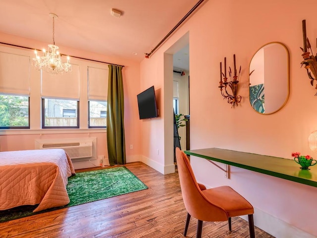 bedroom with a chandelier, light wood finished floors, multiple windows, and baseboards