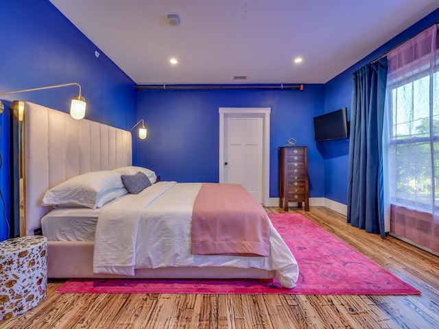 bedroom with wood finished floors, recessed lighting, and baseboards