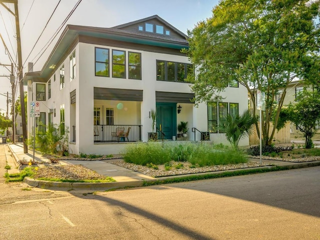 back of property featuring stucco siding and covered porch