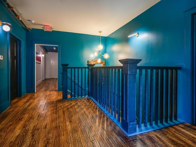 hall with an upstairs landing and wood finished floors