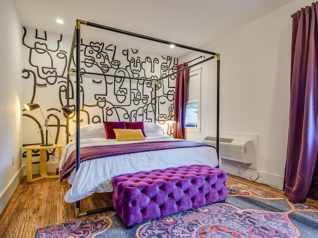 bedroom featuring wood finished floors, a wall mounted AC, baseboards, and recessed lighting
