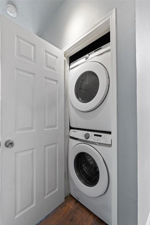2414 Longview St Unit 303, Austin, TX 78705 - washroom featuring estacked washer and dryer and dark wood-type flooring