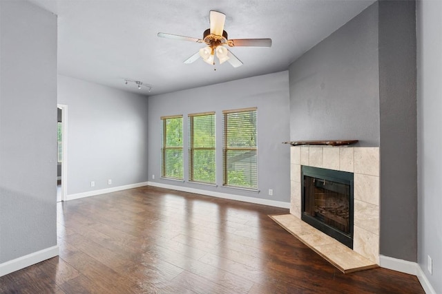 2414 Longview St Unit 303, Austin, TX 78705 - unfurnished living room with a tiled fireplace, dark wood-style floors, and a ceiling fan