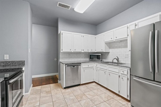 2414 Longview St Unit 303, Austin, TX 78705 - kitchen featuring appliances with stainless steel finishes, tasteful backsplash, and white cabinetry