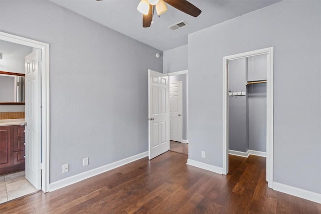 2414 Longview St Unit 303, Austin, TX 78705 - unfurnished bedroom with a walk in closet, wood finished floors, a closet, connected bathroom, and ceiling fan