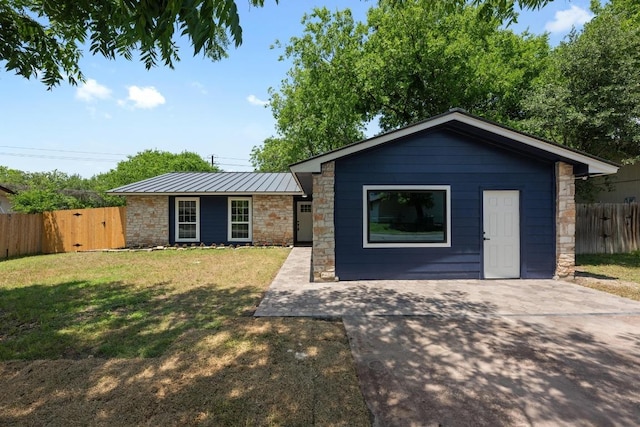 view of front of home with stone siding, a standing seam roof, a gate, and metal roof