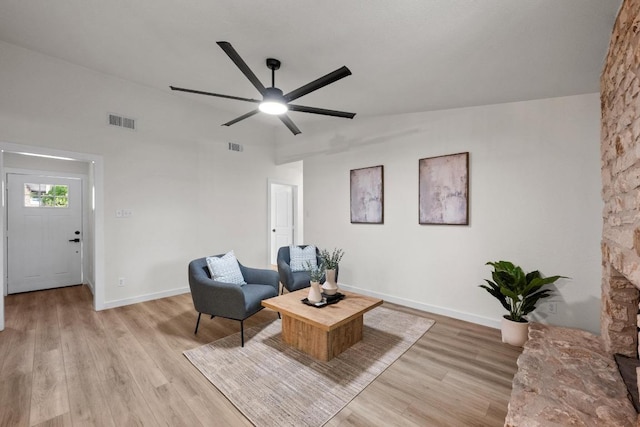 living room with ceiling fan, light wood finished floors, and baseboards