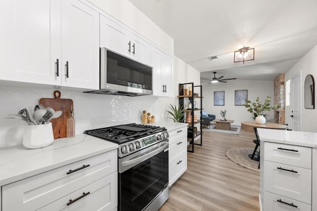 7002 Teaberry Dr, Austin, TX 78745 - kitchen with stainless steel appliances, a ceiling fan, light wood finished floors, tasteful backsplash, and light stone countertops
