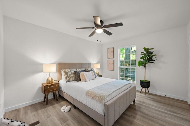 bedroom featuring wood finished floors, baseboards, and a ceiling fan
