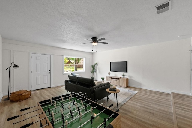 7002 Teaberry Dr, Austin, TX 78745 - living room featuring a textured ceiling, ceiling fan, and light wood finished floors
