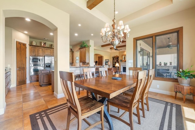 dining space featuring arched walkways, recessed lighting, a chandelier, baseboards, and a ceiling fan