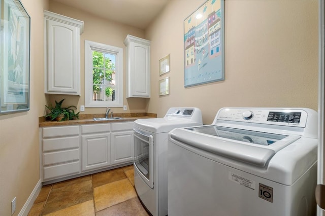 clothes washing area with independent washer and dryer, cabinet space, and baseboards