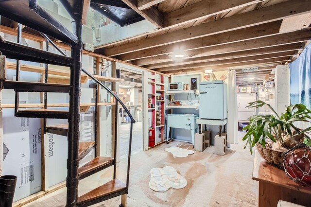 unfinished basement featuring stairway and washer / clothes dryer