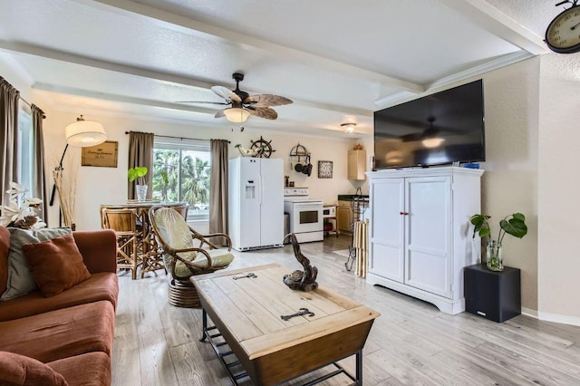 living area featuring light wood-style flooring, beam ceiling, ceiling fan, and baseboards