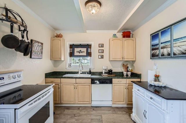 kitchen featuring white appliances, a sink, light brown cabinets, dark countertops, and beamed ceiling