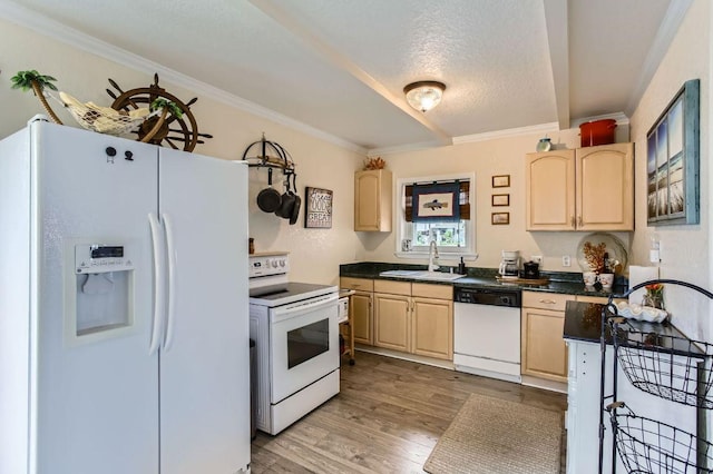 kitchen featuring white appliances, a sink, light brown cabinets, wood finished floors, and dark countertops