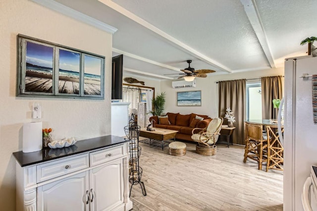 living room featuring light wood-style floors, ceiling fan, beam ceiling, an AC wall unit, and a textured ceiling