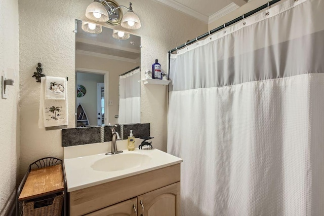 full bath featuring a textured wall, ornamental molding, and vanity