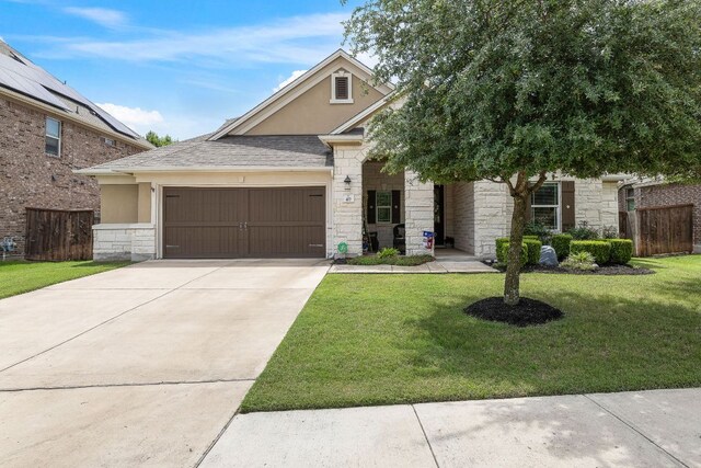 417 Freeman Park Pl, Round Rock, TX 78665 - view of front of house with stone siding, an attached garage, stucco siding, and driveway