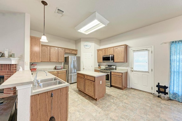 kitchen featuring stainless steel appliances, a sink, light countertops, a center island, and a peninsula