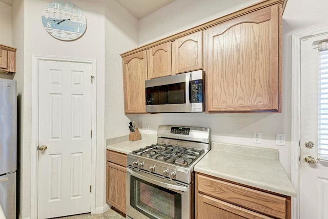 kitchen featuring stainless steel appliances, light countertops, and light brown cabinets