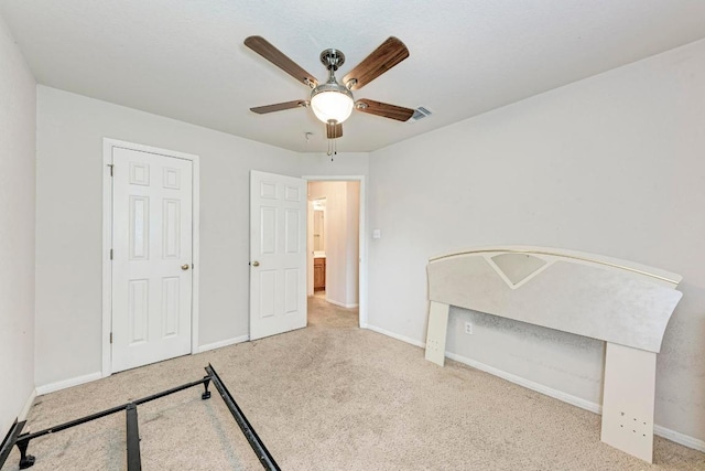 unfurnished bedroom featuring carpet floors, baseboards, and a ceiling fan