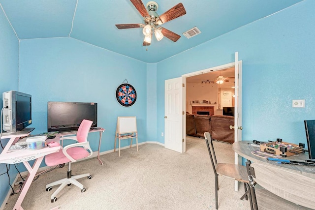 carpeted office featuring lofted ceiling, ceiling fan, a brick fireplace, and baseboards