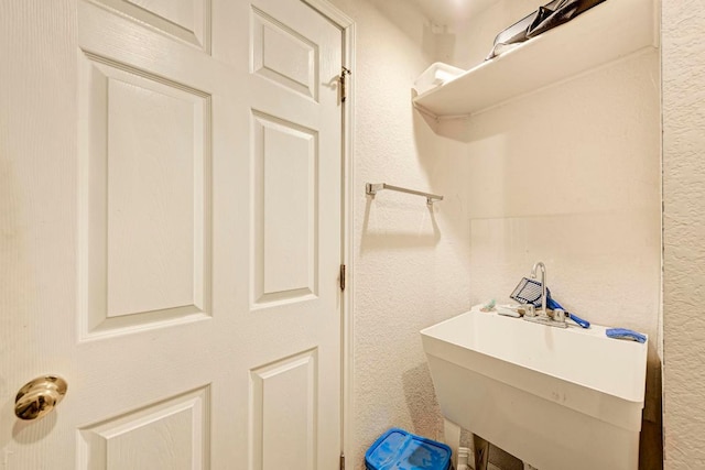 bathroom featuring a sink and a textured wall