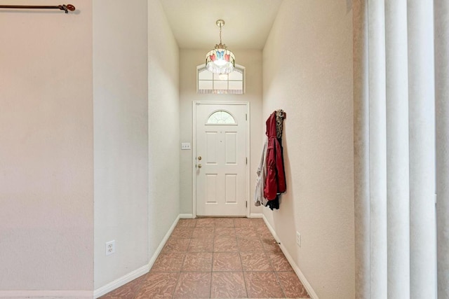 entrance foyer with light tile patterned floors and baseboards