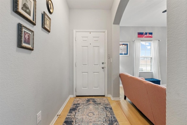 entrance foyer with baseboards and arched walkways
