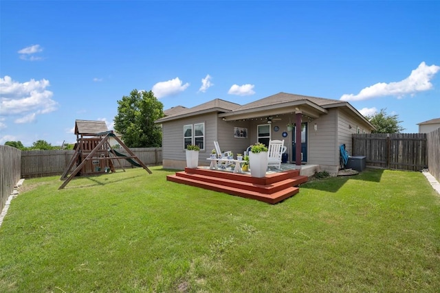 back of property featuring a wooden deck, a playground, and ceiling fan