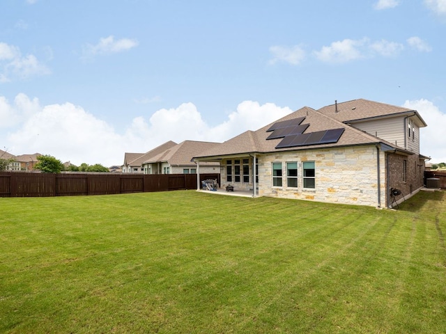 20513 Christie Marie Ln, Pflugerville, TX 78660 - rear view of house featuring roof mounted solar panels, a patio, roof with shingles, stone siding, and central AC unit
