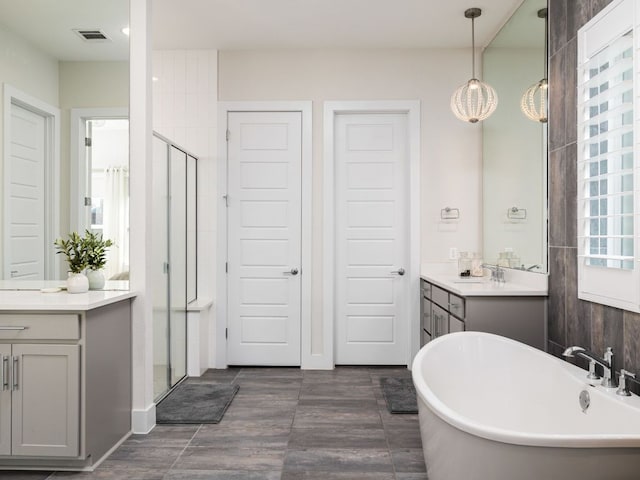 20513 Christie Marie Ln, Pflugerville, TX 78660 - bathroom featuring a shower stall, vanity, a freestanding tub, and a chandelier