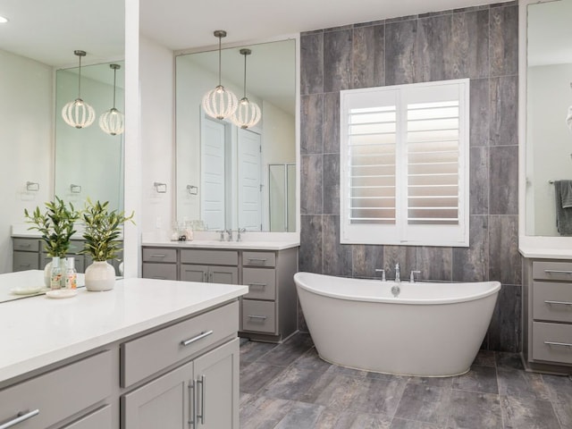 20513 Christie Marie Ln, Pflugerville, TX 78660 - bathroom featuring a soaking tub, tile walls, and vanity