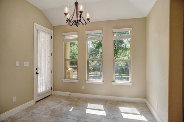 foyer featuring vaulted ceiling, a chandelier, and baseboards