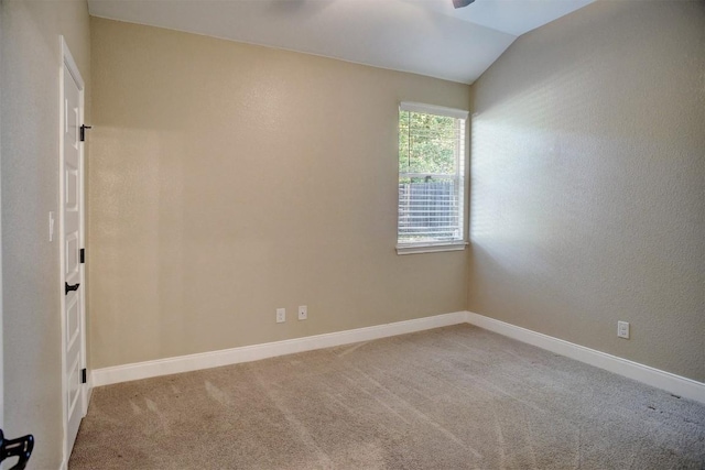 unfurnished room featuring carpet, baseboards, lofted ceiling, and ceiling fan