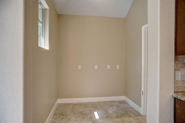 unfurnished room with baseboards