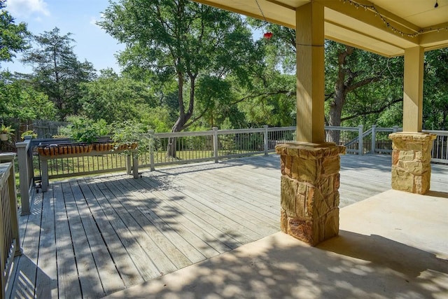 wooden terrace with view of wooded area