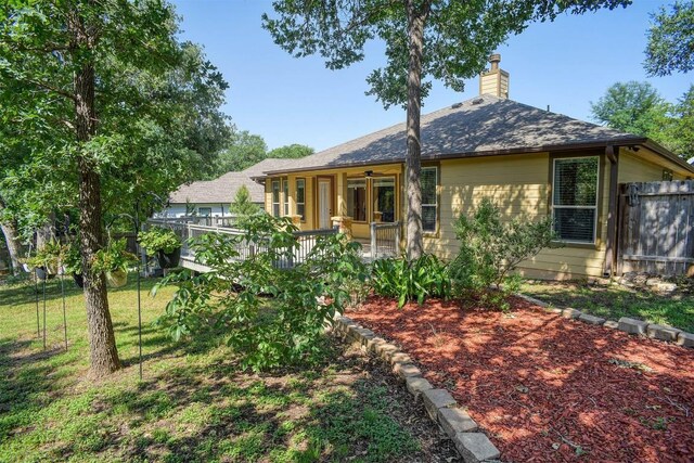 back of property featuring a chimney and a ceiling fan