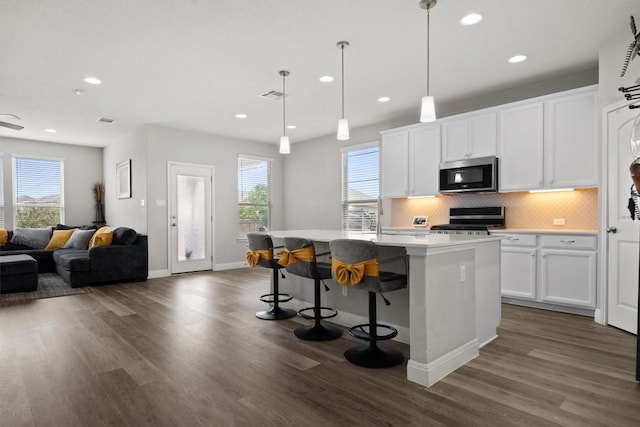 kitchen with stainless steel appliances, backsplash, dark wood-style flooring, light countertops, and recessed lighting