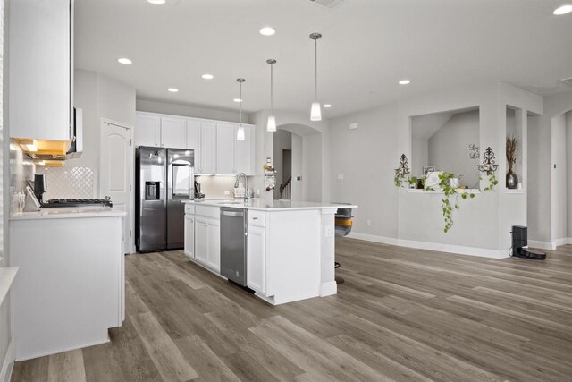 7404 Leonardo Dr, Round Rock, TX 78665 - kitchen with appliances with stainless steel finishes, arched walkways, wood finished floors, a sink, and recessed lighting